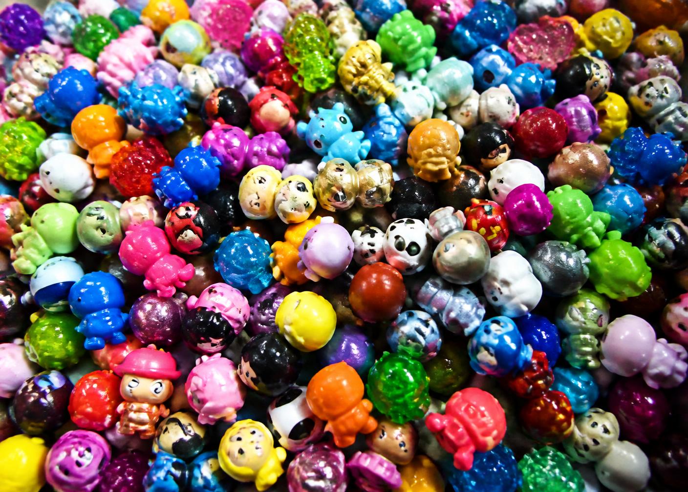 Bright flat-lay of collectible vinyl figures, holographic trading cards and marbles